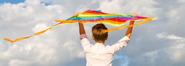 Photo portrait of a child 8-9 years old with a kite a blond boy stands and looks into the distance