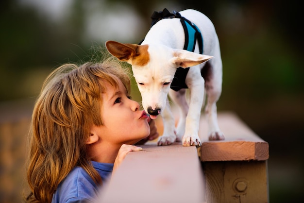 Ritratto bambino ragazzo bacio cucciolo cane amico animale domestico foto divertente di bambino felice che abbraccia bellissimo cucciolo di cane