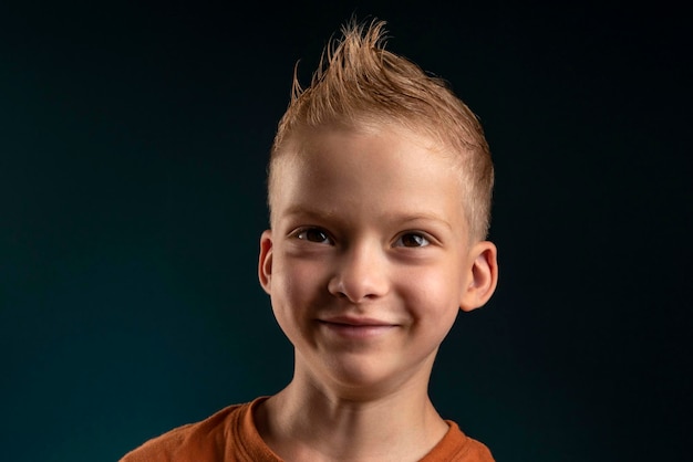 7の暗い背景の男の子の子にブロンドの髪を持つ子供の男の子の肖像画