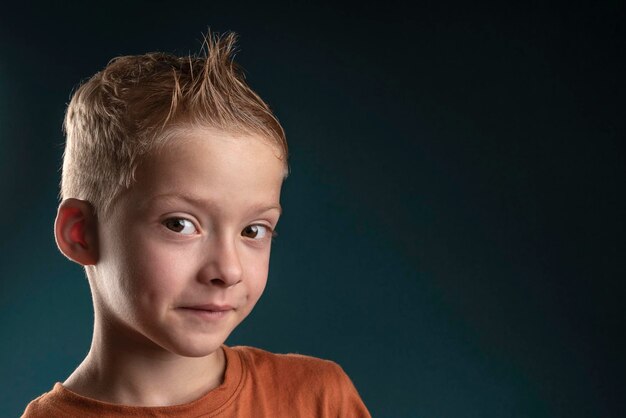 Portrait of a child boy with blond hair on a dark background Boy child of seven