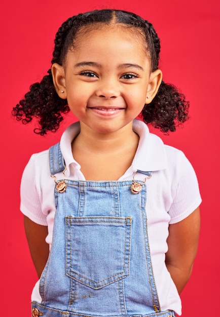 Portrait child and girl in studio happy and smile against a red background with mockup Face cheerful and trendy toddler standing against space excited and positive smiling and posing isolated