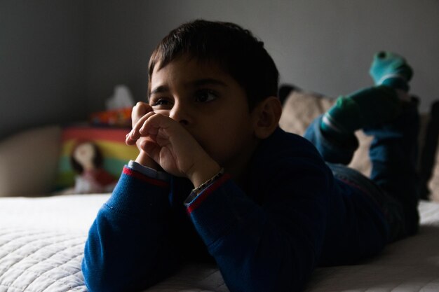 Photo portrait of child lying on the bed