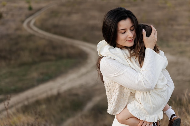 portrait of a child and mother hugging in the evening on a natural background