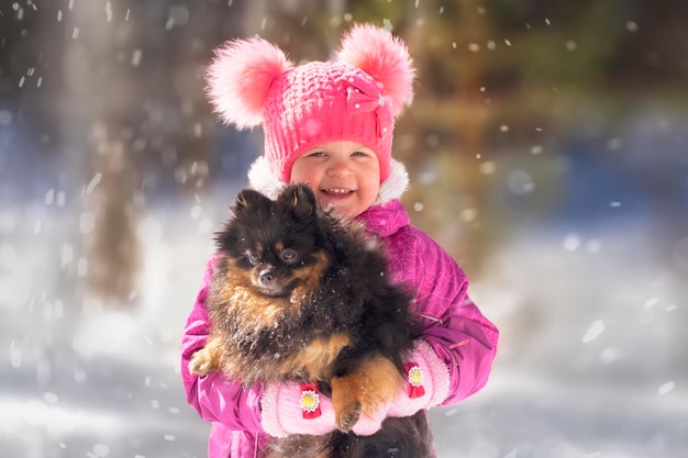 冬に犬と立っている子供の肖像画
