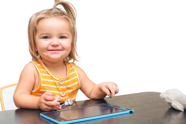 흰색 배경에 고립 된 그래픽 태블릿 장난감으로 테이블에 아이의 초상화