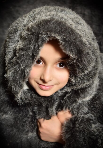 Foto ritratto di un bambino che indossa un cappotto di pelliccia