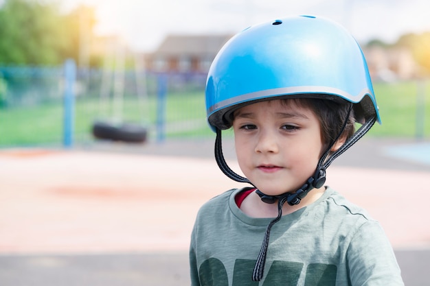 안전 헬멧을 착용하는 어린이의 초상.