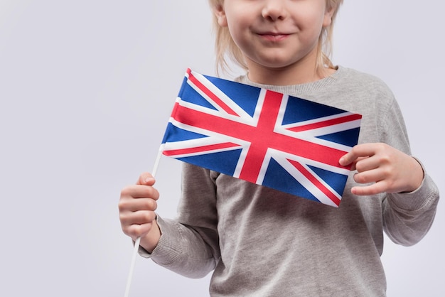 クローズアップで英国の旗を持つ子供の肖像画イギリス英語を勉強する