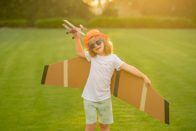 Photo portrait of child with toy paper wings outdoor success creative and start up concept