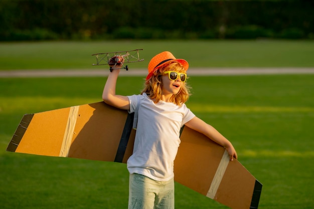 Portrait of child with toy paper wings outdoor Success creative and start up concept