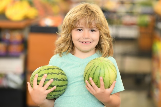 Portrait of child with watermelon in a food store supermarket shopping and grocery shop concept shop