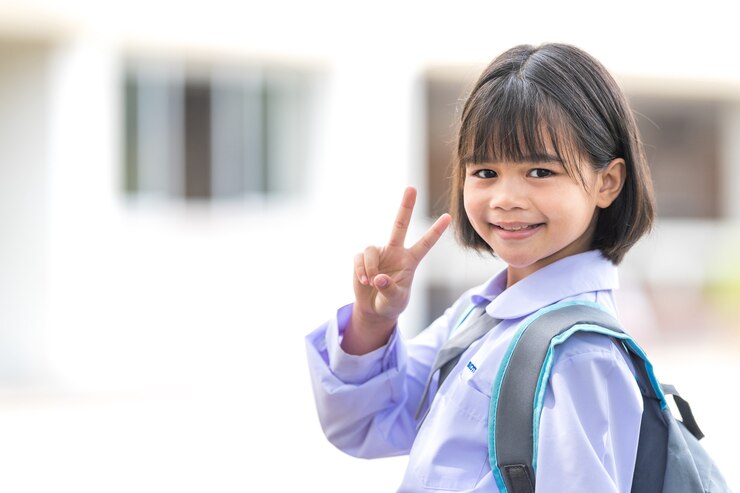 교복과 배낭을 입은 어린이 학생의 초상화 covid-19 검역 및 폐쇄 후 학교로 돌아가는 카메라를 바라보고 있습니다. 학교 개념으로 돌아가기 스톡 포토