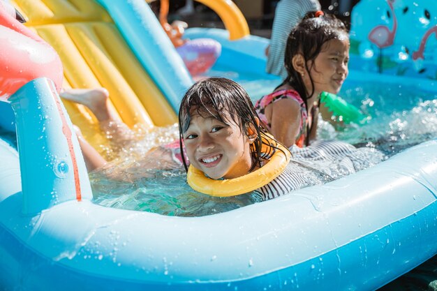 Ritratto di bambini molto felici che giocano acqua insieme nel parco giochi