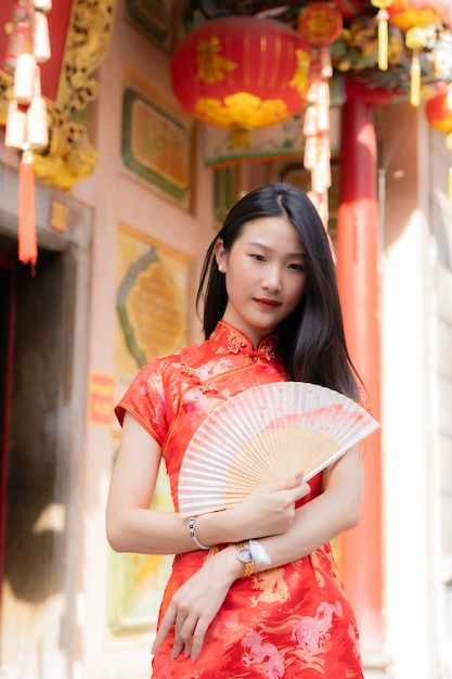 手に紙扇子を保持している中国の服を着ている中国の女の子の肖像画