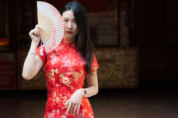 Photo portrait of chinese girl wearing chinese clothes posing at cement door