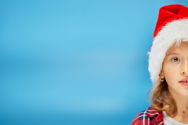 Portrait of Christmas little Girl in Santa Hat, smiling