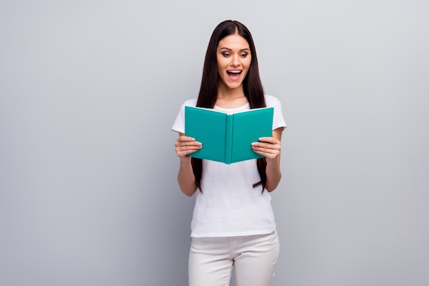 Portrait of clever charming girl reading interesting book