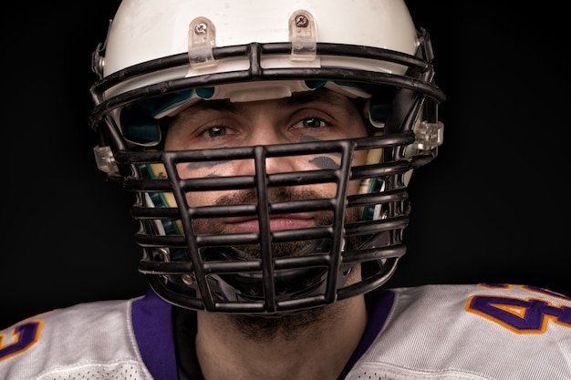 Photo portrait close-up, american football player, bearded in helmet.