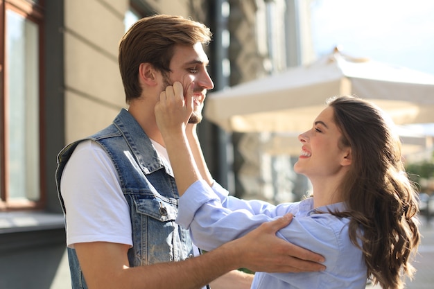 Portrait closeup of attractive people man and woman 20s hugging and smiling while walking through green park