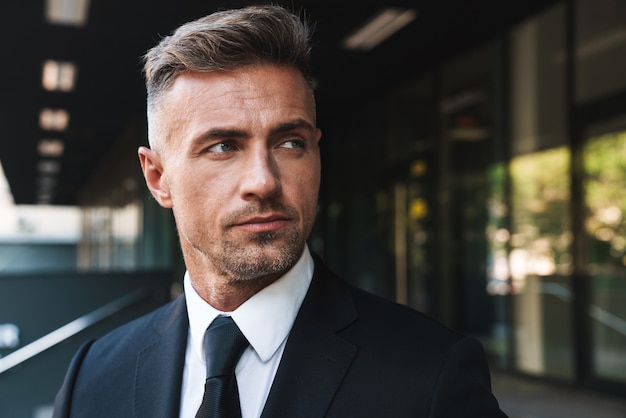 Portrait closeup of handsome businessman dressed in formal suit standing outside job center during working meeting