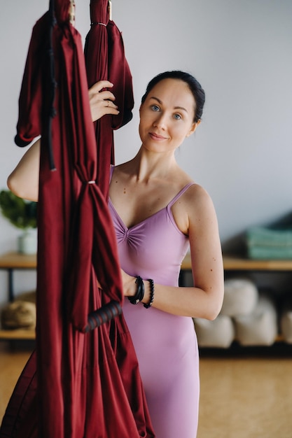 Portrait of a coach girl standing near a hanging hammock in the gym