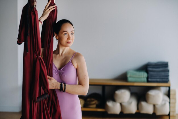 Portrait of a coach girl standing near a hanging hammock in the gym