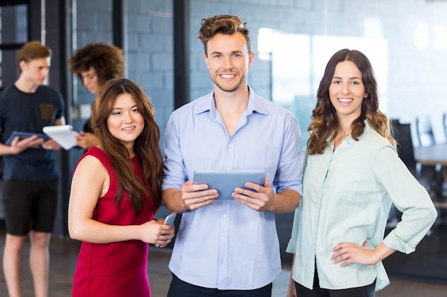 Portrait of colleagues holding a digital tablet and smiling