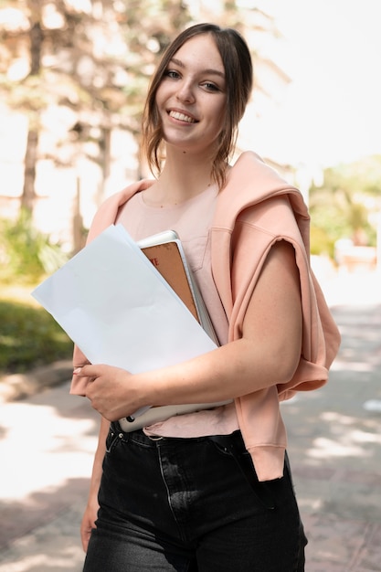 Portrait of college student holding some books