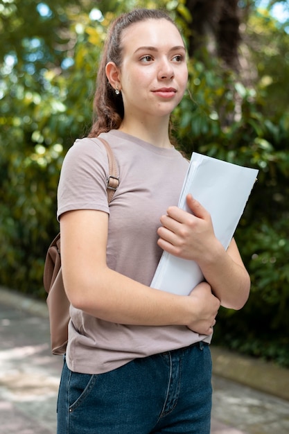 Photo portrait of college student holding some books