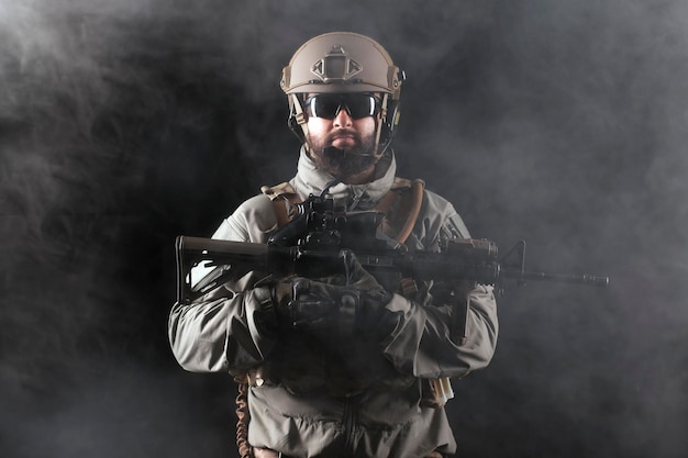어두운 배경의 엘리트 부대에 대항하는 무기를 든 제복을 입은 특공대의 초상화