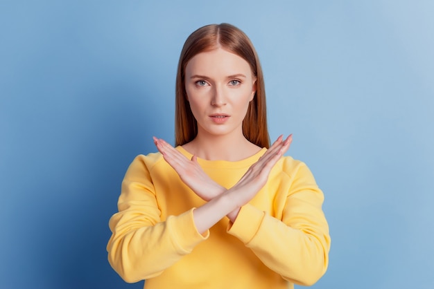 Portrait of concentrated confident lady crossed hands show rejection sign on blue background