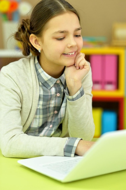 Portrait of concentrated little girl with laptop studying