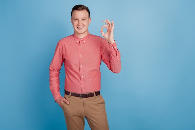 Portrait of confident adviser nice attractive guy show okey sign on blue background