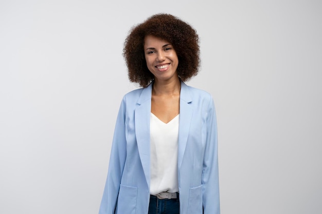 Portrait of a confident African American young business woman smiling at camera on white background