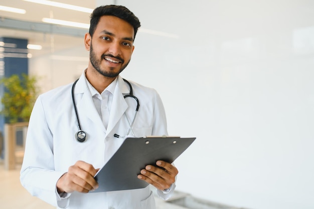 Portrait of confident Asian Indian medical doctor standing at hospital building