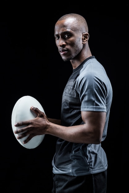 Portrait of confident athlete standing with rugby ball