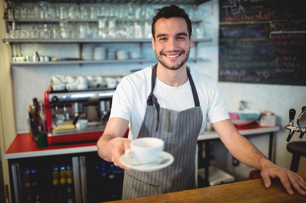 Ritratto di barista fiducioso che serve caffè al caffè