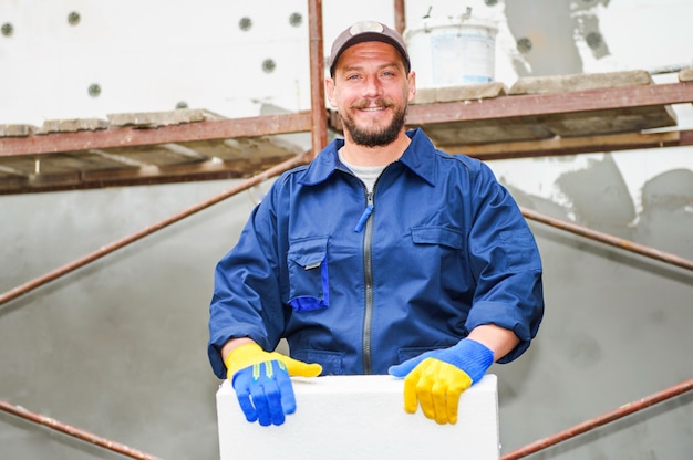 Portrait of confident bricklayer at construction site.