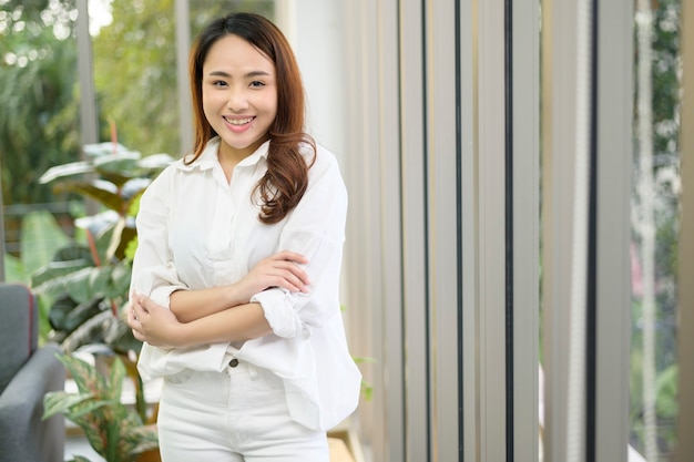 Портрет уверенно деловой азиатской женщины в белой рубашке в офисе