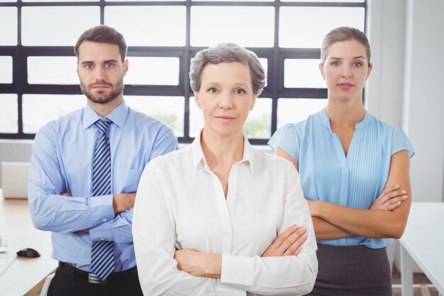 Portrait of confident business people by desk in office