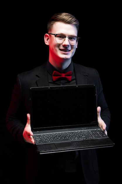 Portrait of confident businessman showing laptop