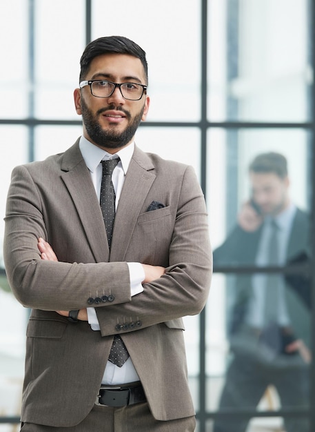 Portrait of confident businessman with arms crossed in office