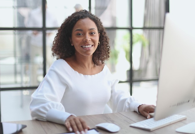 Portrait of a confident businesswoman with team in the background