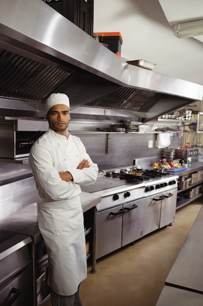 Photo portrait of confident chef standing with arms crossed in commercial kitchen