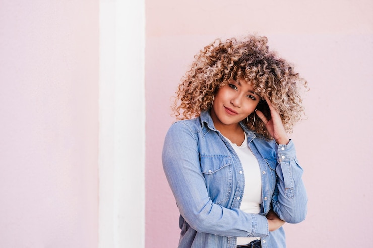 Photo portrait of confident curvy hispanic woman outdoors in spring pink wall body positivity