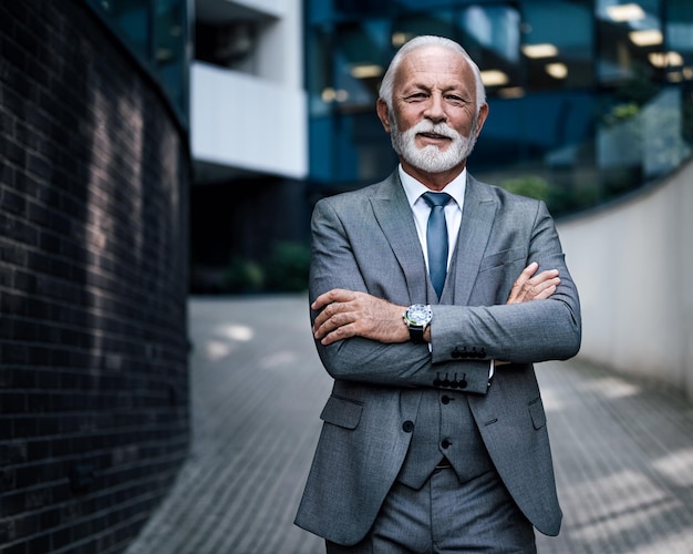 Portrait of confident entrepreneur standing on walkway outside modern office buildings