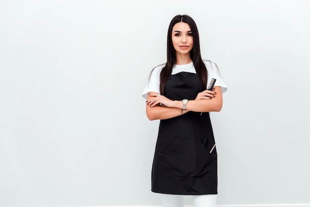 Portrait of a confident female hairdresser standing hands folded