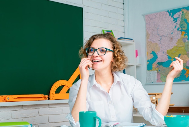 Portrait of confident female teacher near blackboard in classroom at school Happy teacher