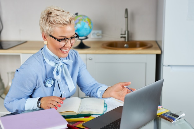 Portrait of confident good looking teacher sitting at table