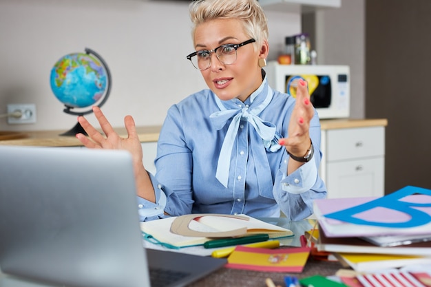 Portrait of confident good looking teacher sitting at table